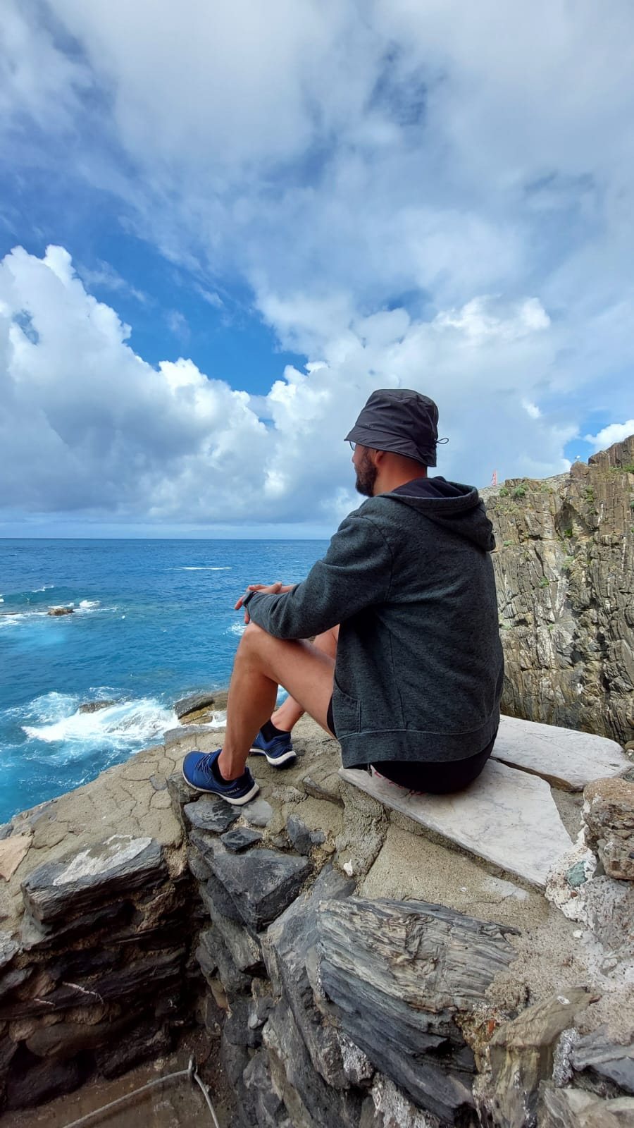 Flavius sitting on a cliff, looking out toward the sea