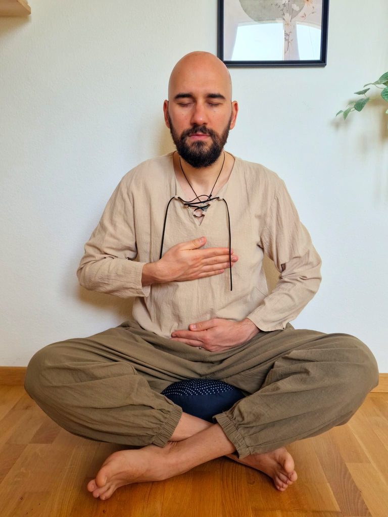 Flavius meditating cross-legged with a hand on his heart