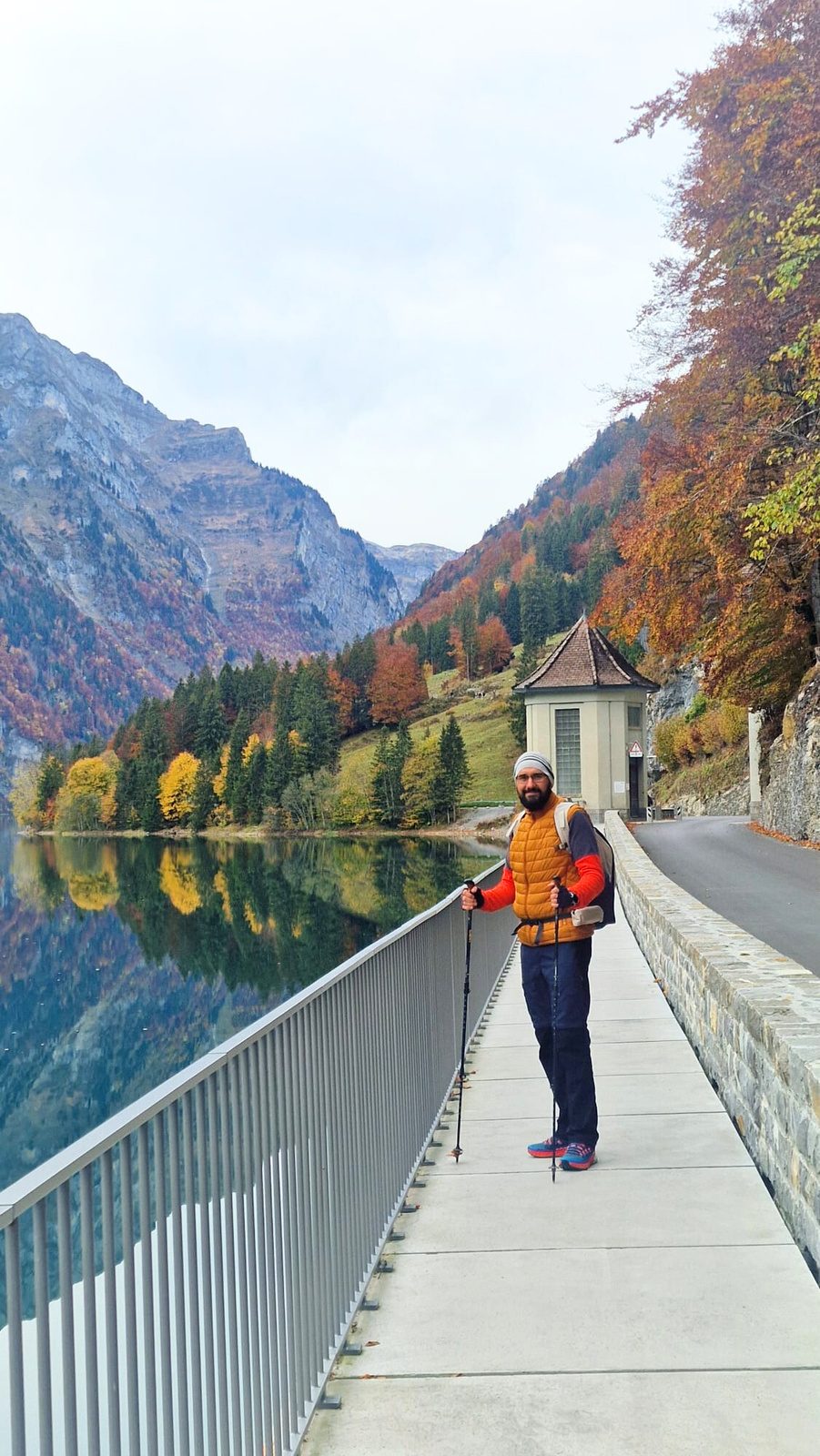Flavius hiking across a bridge by a mountain lake in autumn